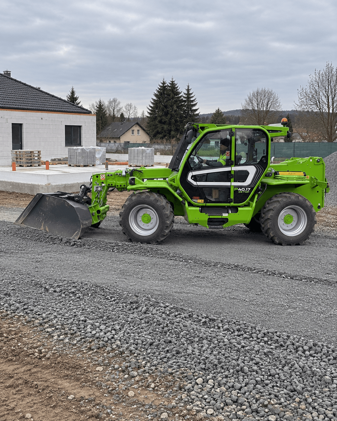 Merlo P40.17 srovnává lopatou navezený štěrk na staveništi